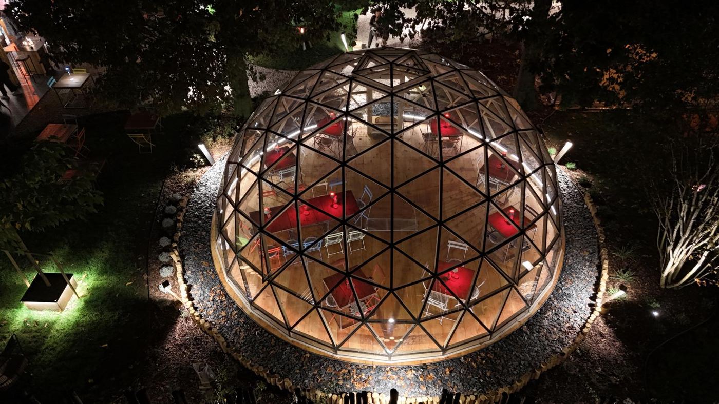 Night aerial of the lantern-lit dome in the farm garden